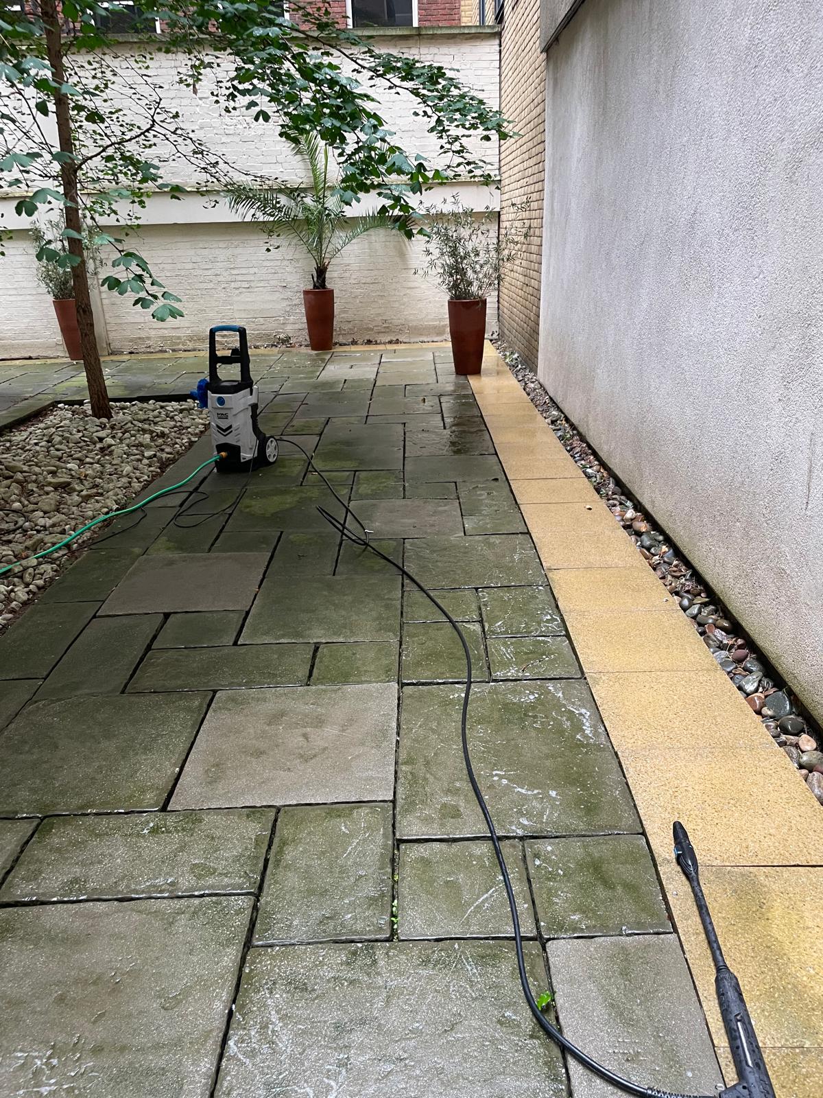 Moss-covered outdoor patio paving before pressure washing
